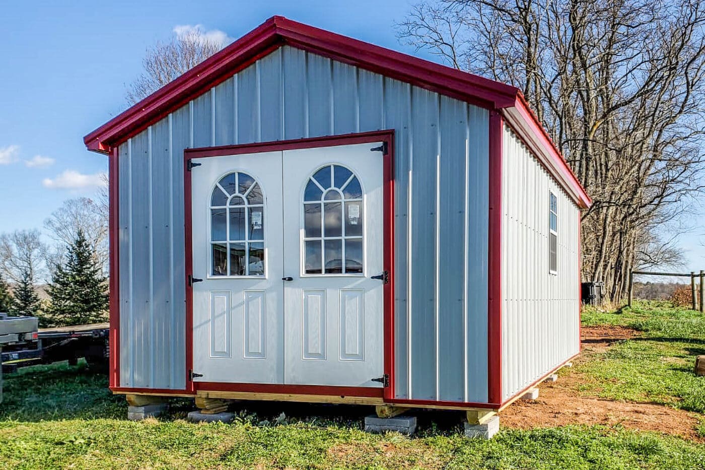 Metal storage building with double doors and red trim, showcasing Premier Structures’ craftsmanship.