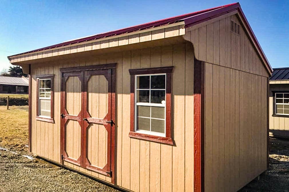 Beige and red finished Quaker building with red-trimmed double doors and windows