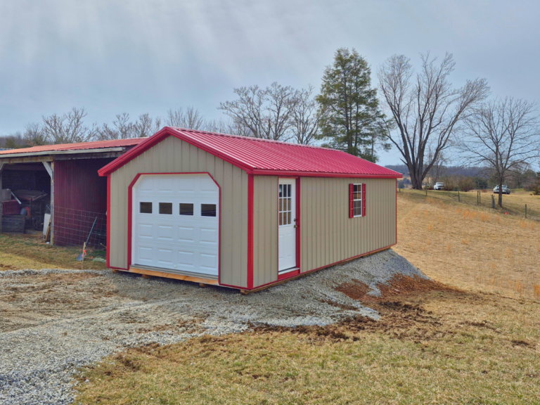 brown single car garage with a red roof and trim on a dirt pile beside a loafing shed in wytheville virginia that was delivered by premier building solutions on 3/7/2025