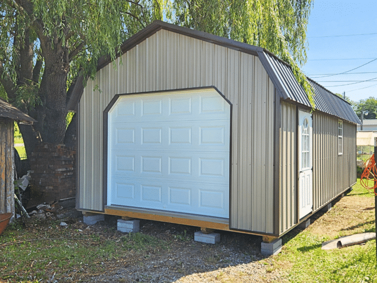 a tan single car garage with a white overhead door and one side door as well as two windows
